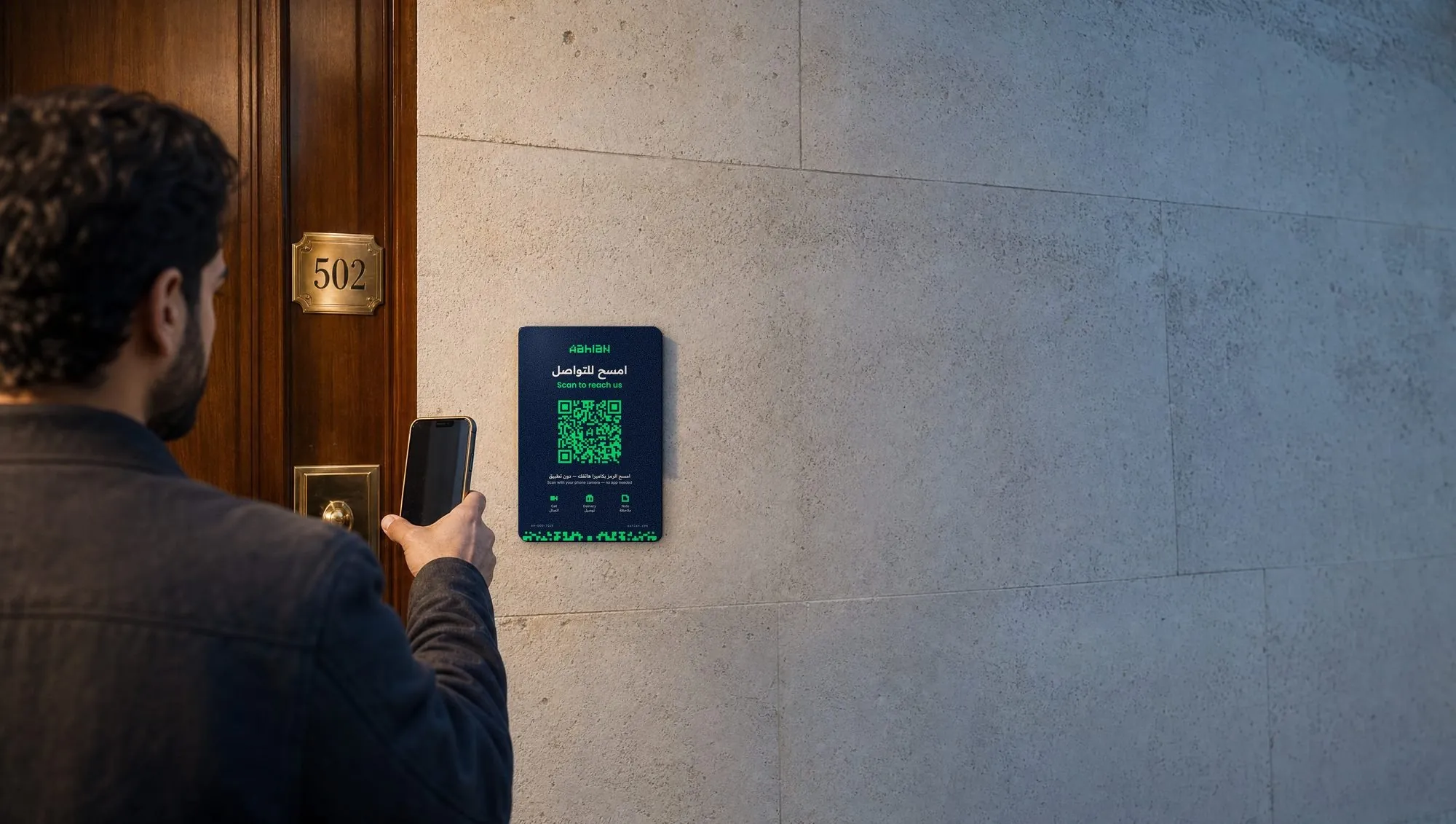 A visitor scans an Aahlan door sticker beside an apartment door with his phone.